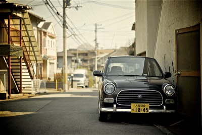 弱光摄影的汽车旁边米色建筑
